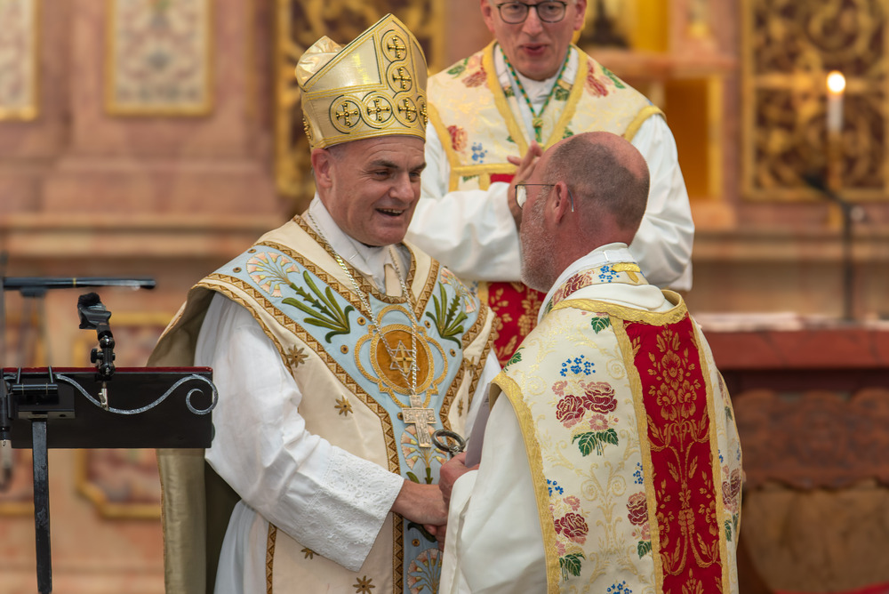 Bischof Muser (links) überreicht P. Kosmas den Klosterschlüssel