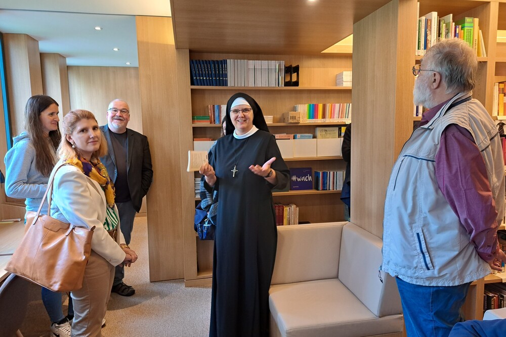 Priorin Sr. Magdalena Niescioruk OSB  führt durch die hauseigene Bibliothek